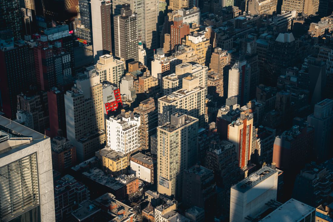 Aerial view of dense Manhattan skyscrapers and rooftops in warm late-afternoon light