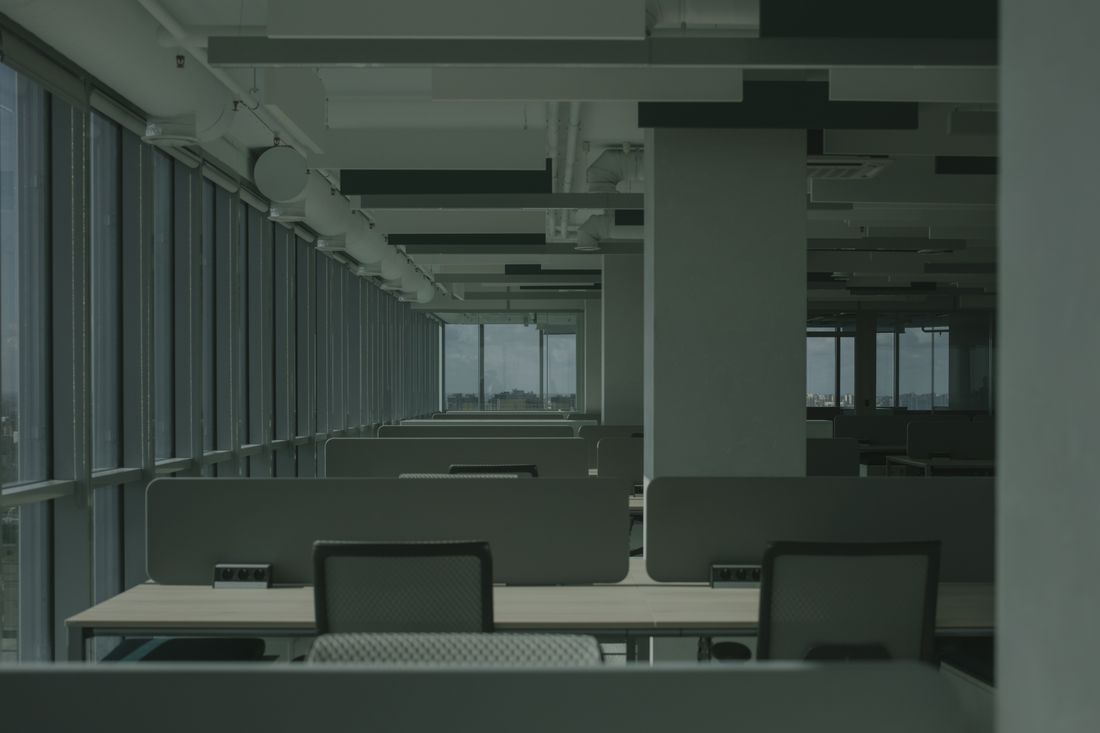 A spacious, empty modern office with floor-to-ceiling windows and natural daylight, an example of the kind of real working environment sustainability leadership content should show.