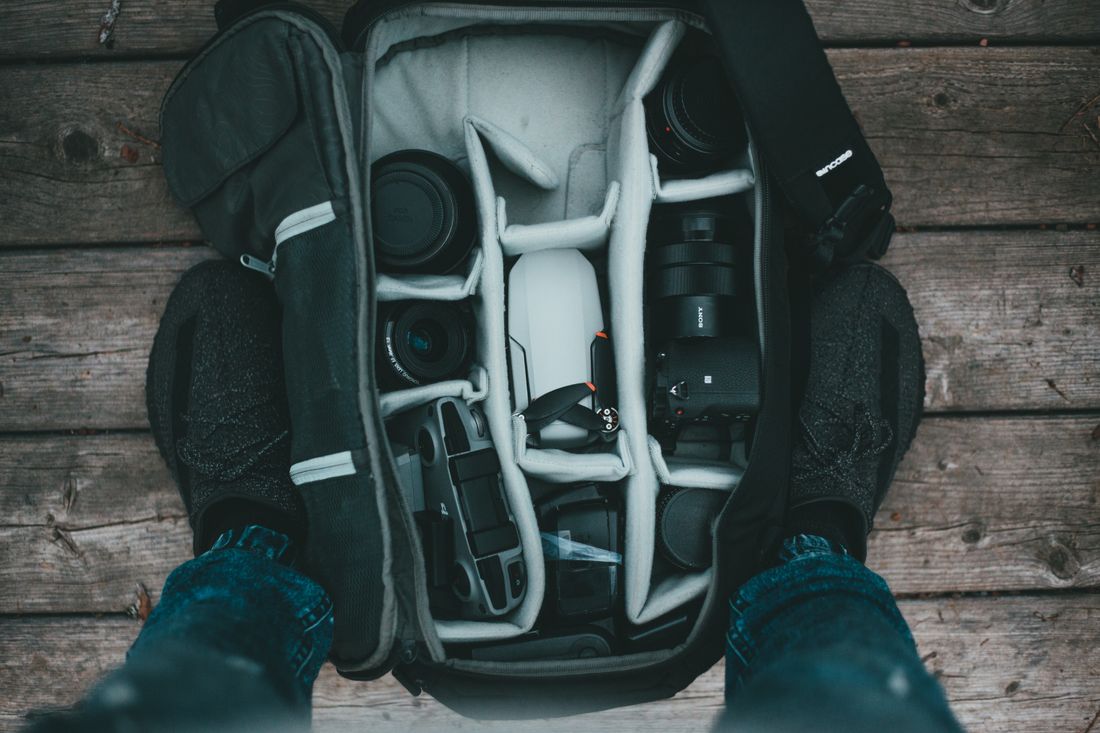 A photographer's camera bag packed with a body and lenses, ready to move between rooms.