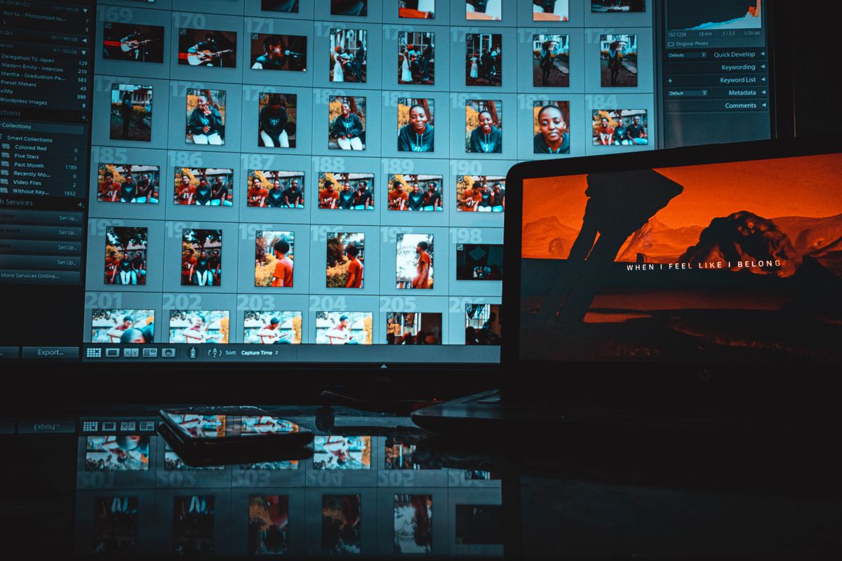 A large grid of thumbnail photos filling a computer screen next to a laptop, representing a searchable conference photo library