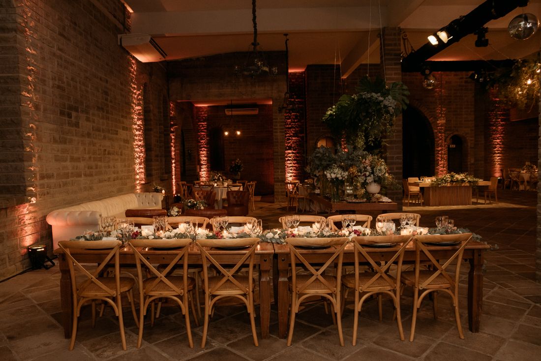 Decorated dining space with wooden tables and floral arrangements under warm lighting