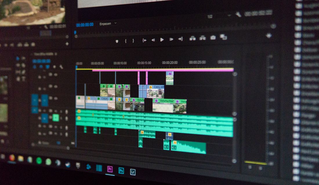 Close-up of a video editing timeline on a monitor, showing clips and audio tracks arranged before a polish pass.