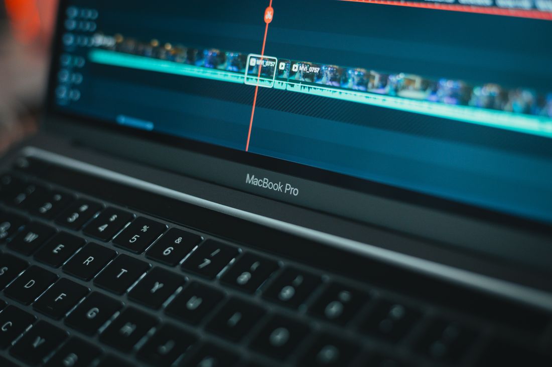 Close-up of video editing software on a laptop screen showing a timeline with multiple clips