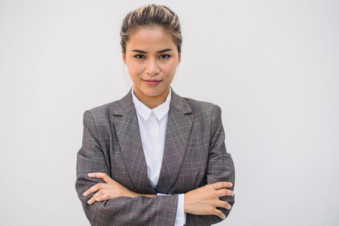 A confident, warm portrait of a business leader in a blazer against a plain background.