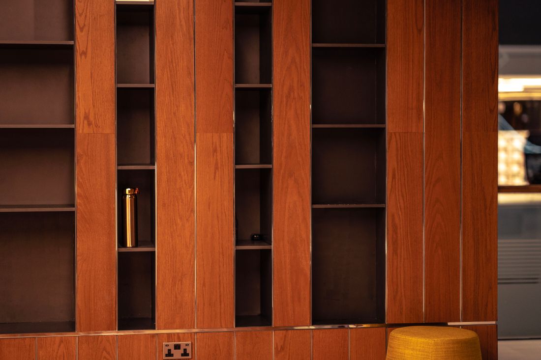 Warm wood-paneled shelving in an office interior, evoking an established, multi-generation business.