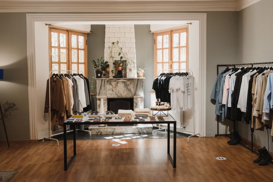 Clothing racks and a styled display table set up inside a gallery-style presentation room.