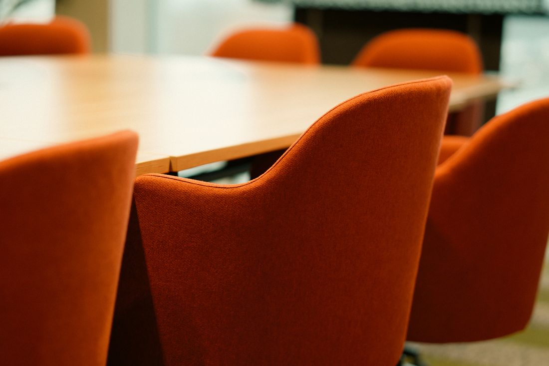 An empty modern conference table and chairs, elegant and understated, with nobody present.