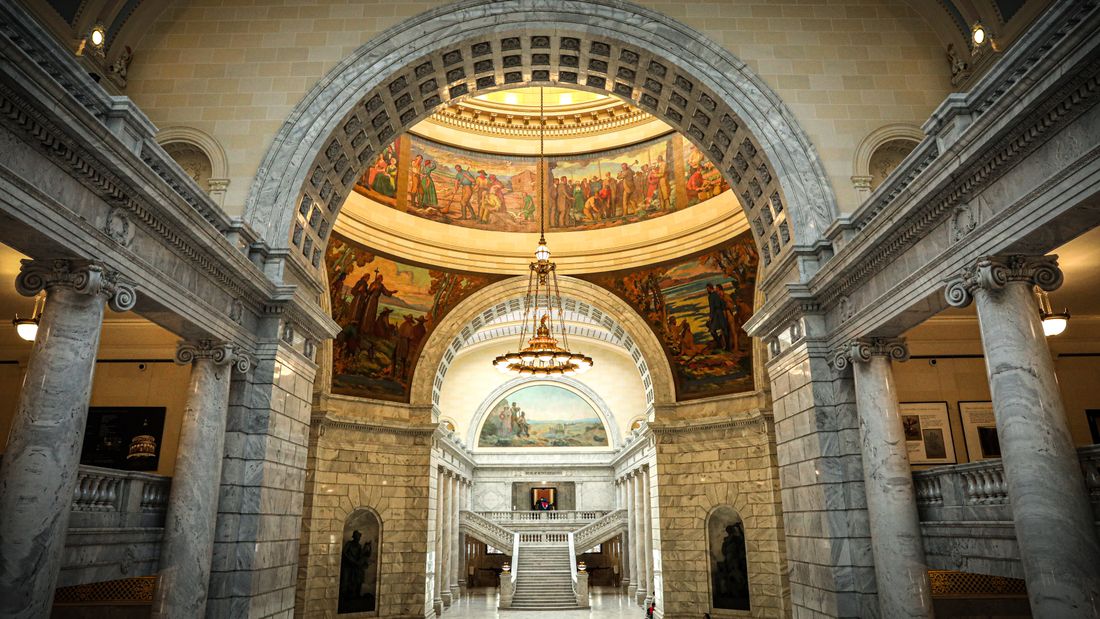 Grand marble rotunda and staircase inside a state capitol building, the kind of public interior civic staff headshots often get shot around.