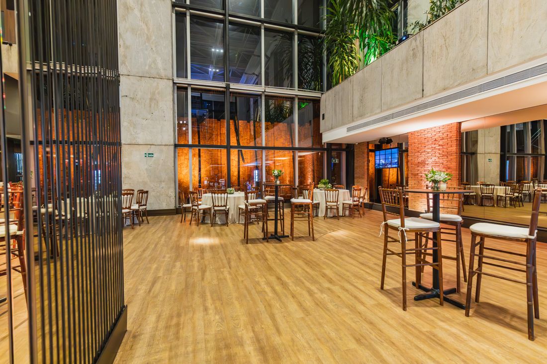 An empty evening reception lounge with cocktail tables and ambient lighting, set up separately from a daytime program