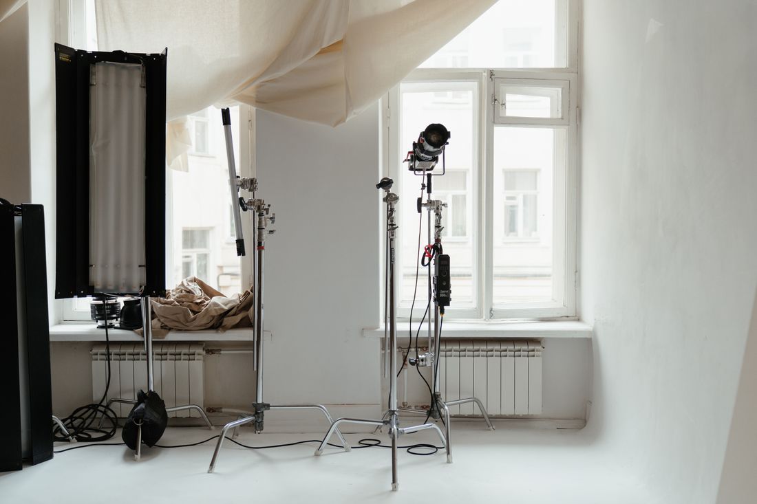 Minimalist photography studio setup with lighting equipment and natural window light, representing a neutral background choice for a headshot system