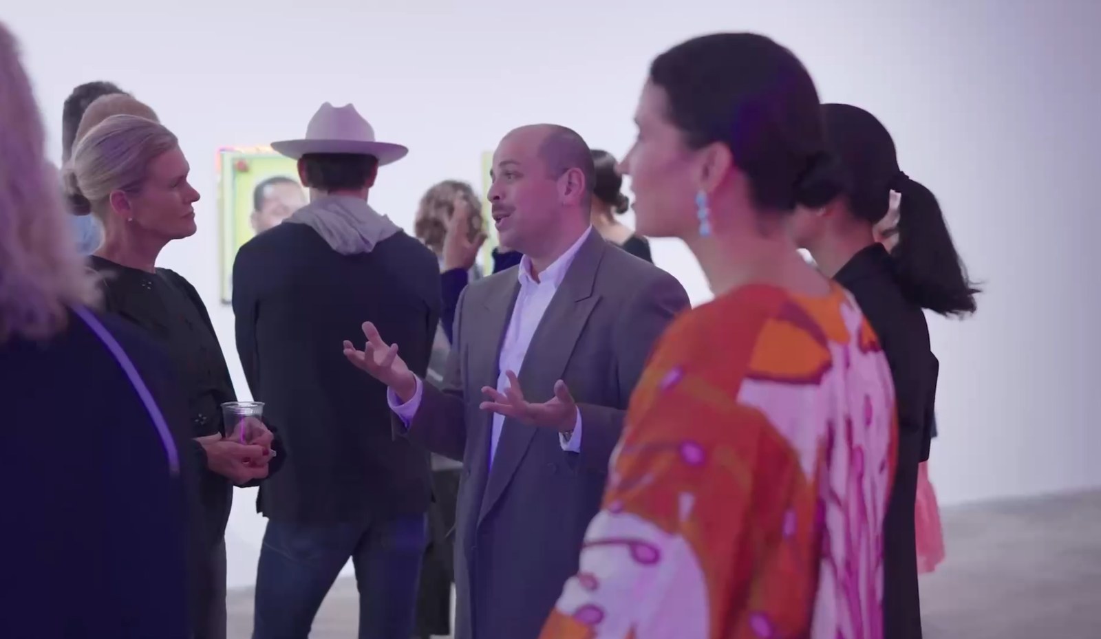 Group in business casual attire standing and conversing outdoors.