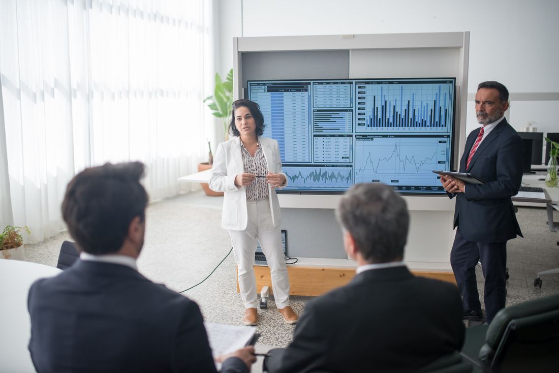Colleagues discussing financial charts during a corporate meeting in a modern office