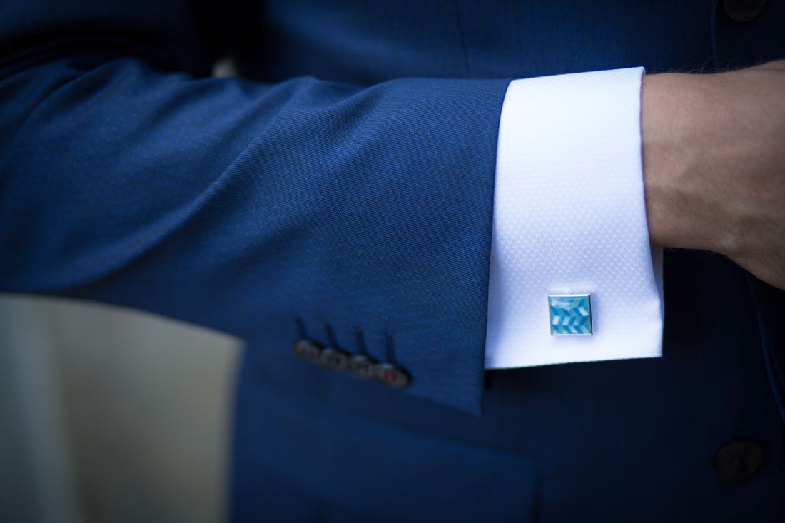 Close-up of a tailored blue suit sleeve and cufflink, the kind of wardrobe detail a consulting headshot needs to get right.