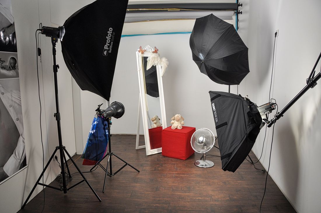 An empty photography studio with softbox lighting stands set up for a portrait session.