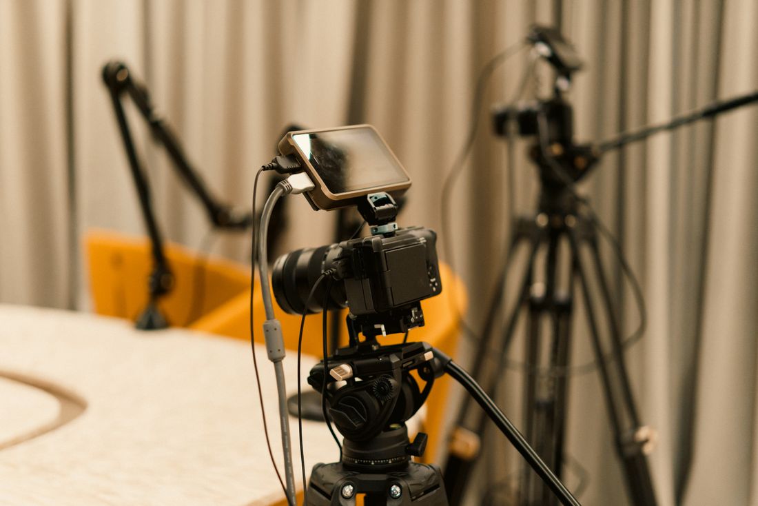 Studio setup with a camera and microphone on tripods, arranged for recording video alongside stills