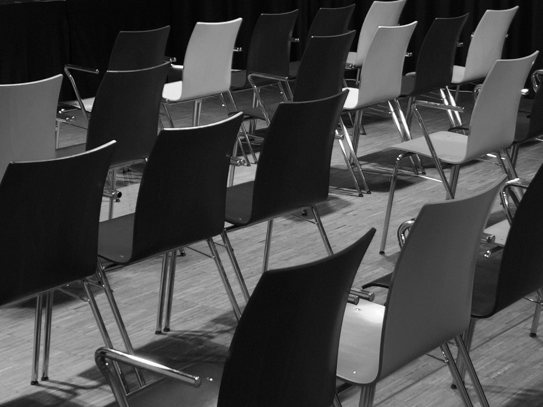 Rows of empty chairs set up in a room, prepared ahead of a group session.