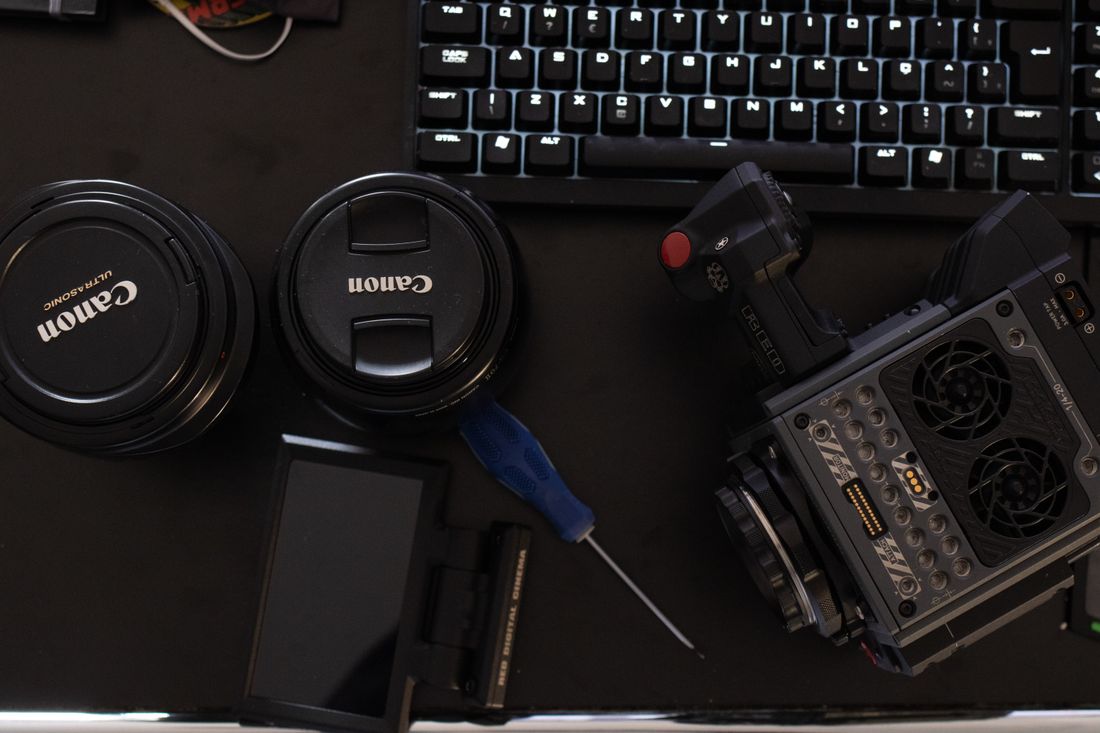 Overhead view of camera lenses and lens caps beside a keyboard, the kind of compact kit used for a single-day personal branding shoot
