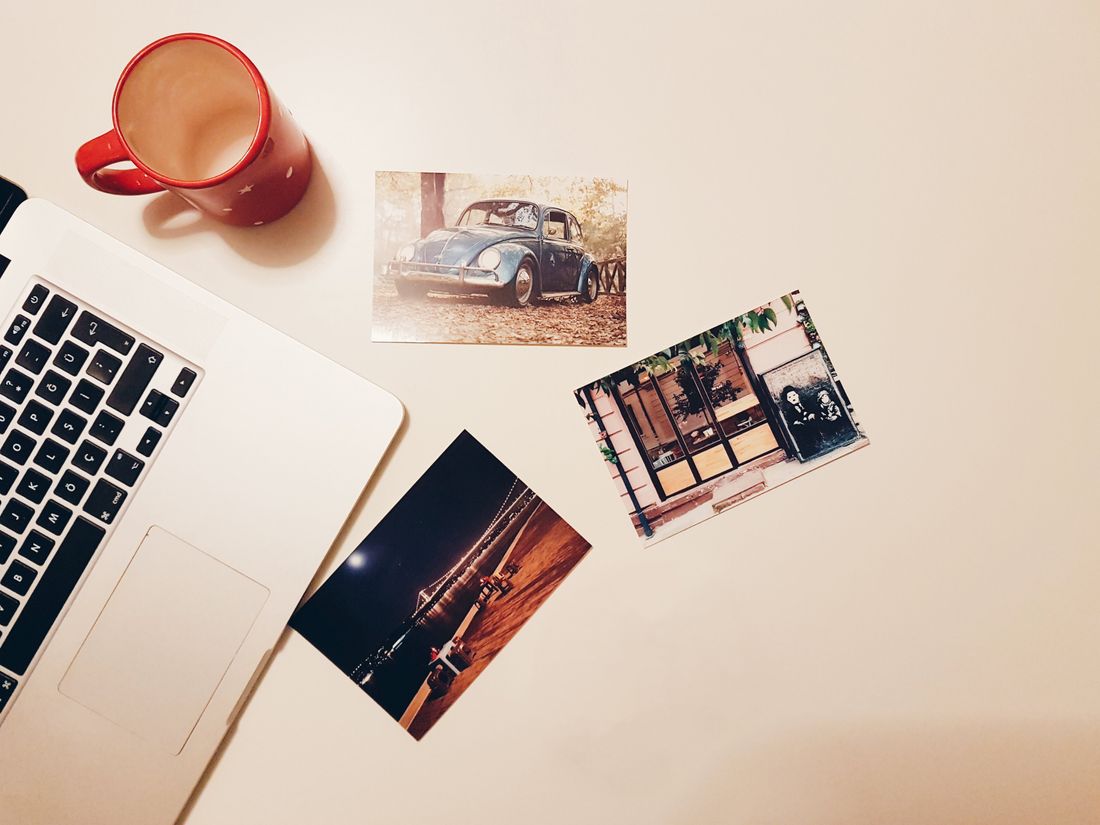 Printed photos next to an open laptop and a coffee mug on a desk, representing personal branding photography