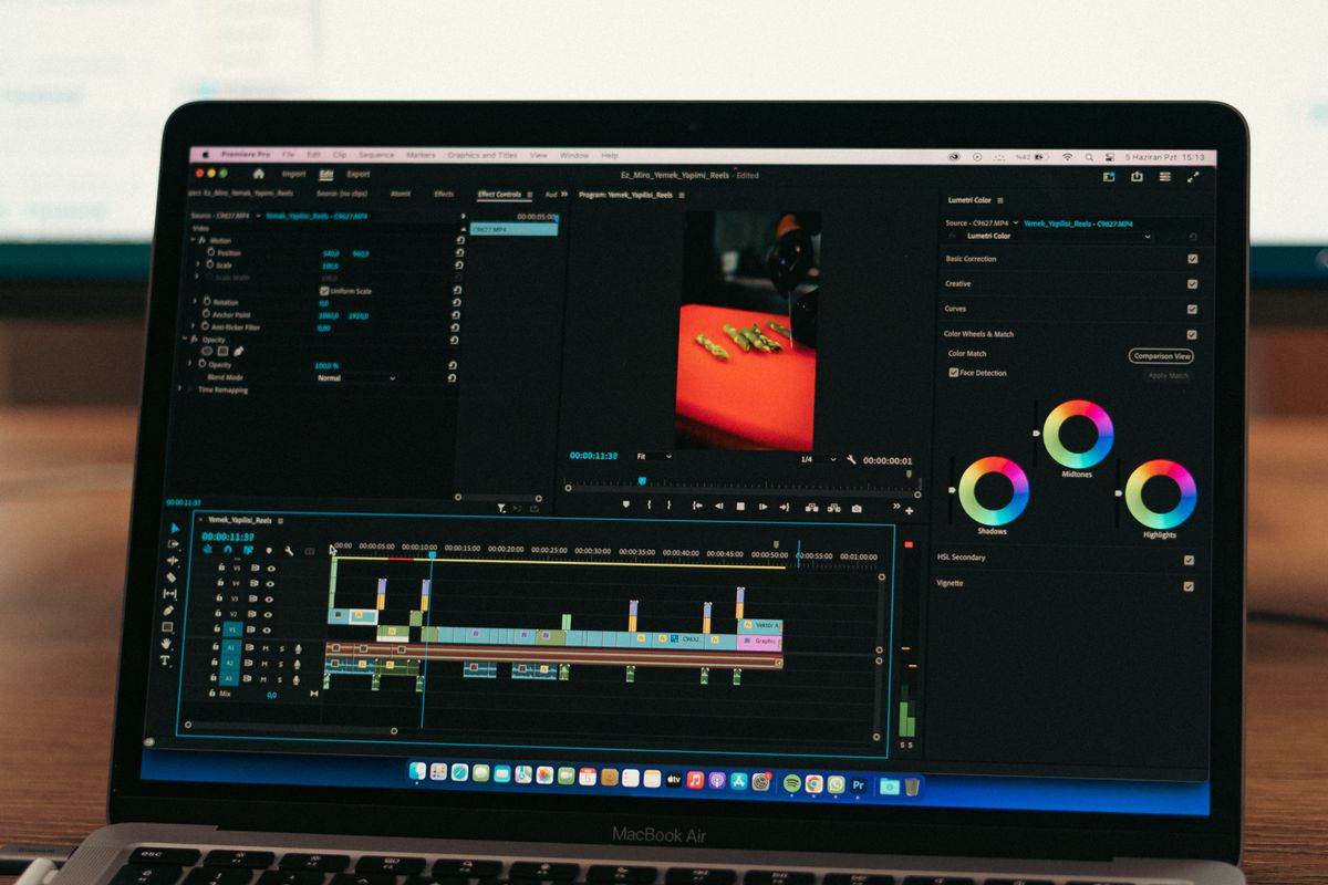 A laptop screen showing video editing software with a timeline and color grading tools, representing founder video production