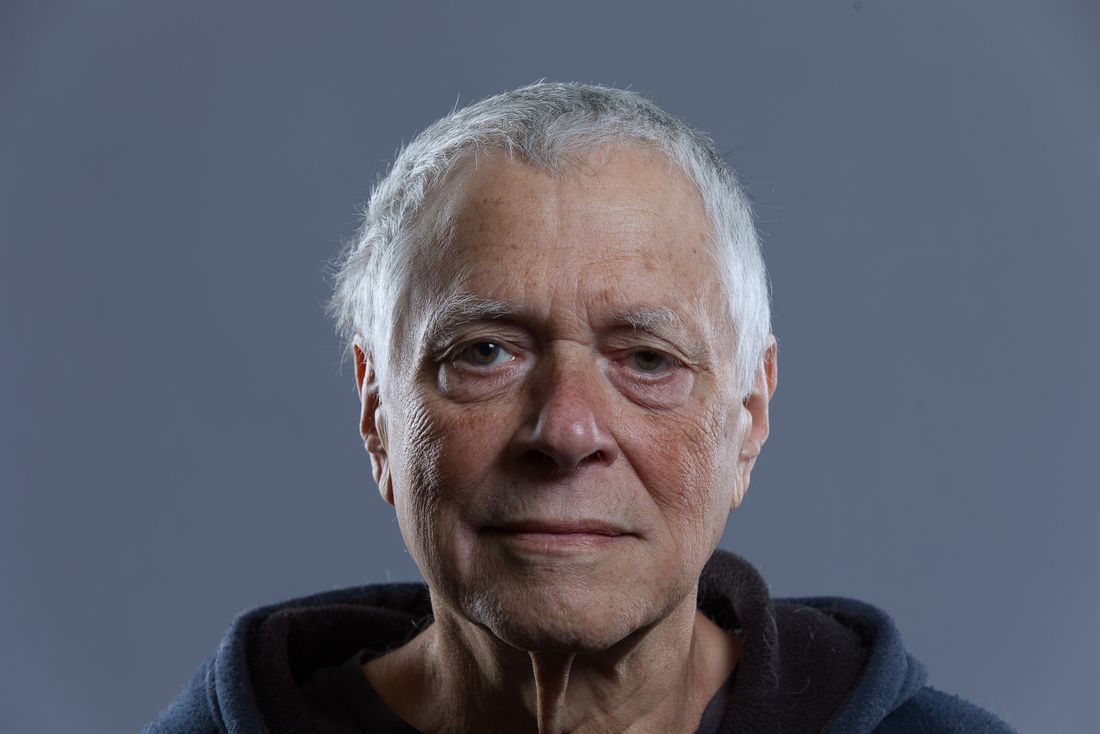 Portrait of a man photographed against a plain, evenly lit neutral background with no branding or logo visible