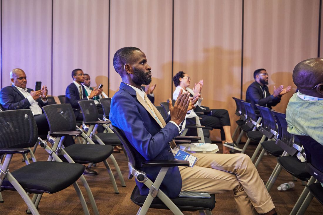 Group of professionals applauding during a business presentation, representing an unveiling moment.
