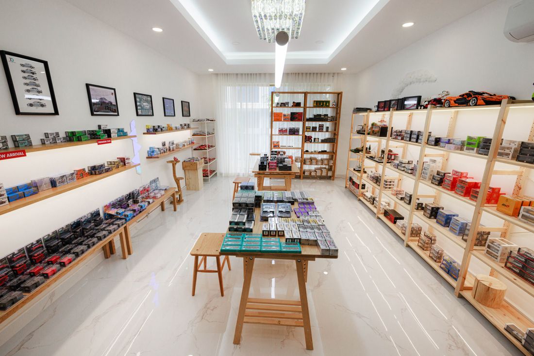 A newly finished retail interior with fully stocked wooden shelving and a central display table, photographed with no customers in the room