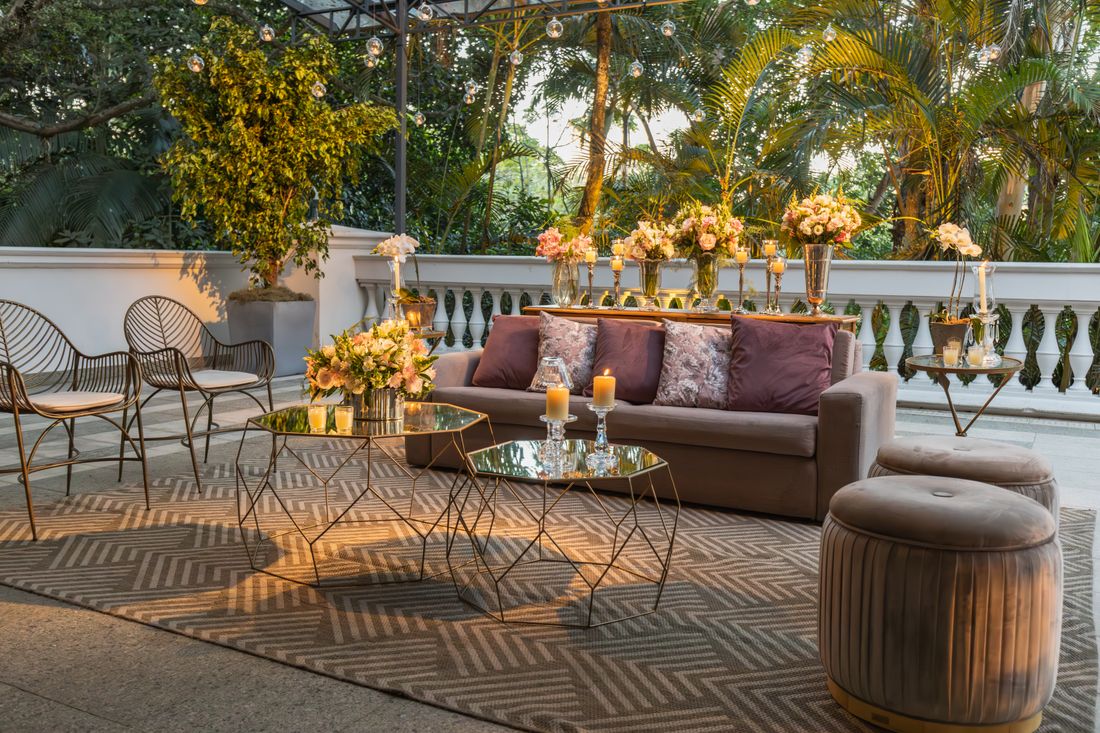 Outdoor terrace lounge area with a sofa, glass tables, and plants