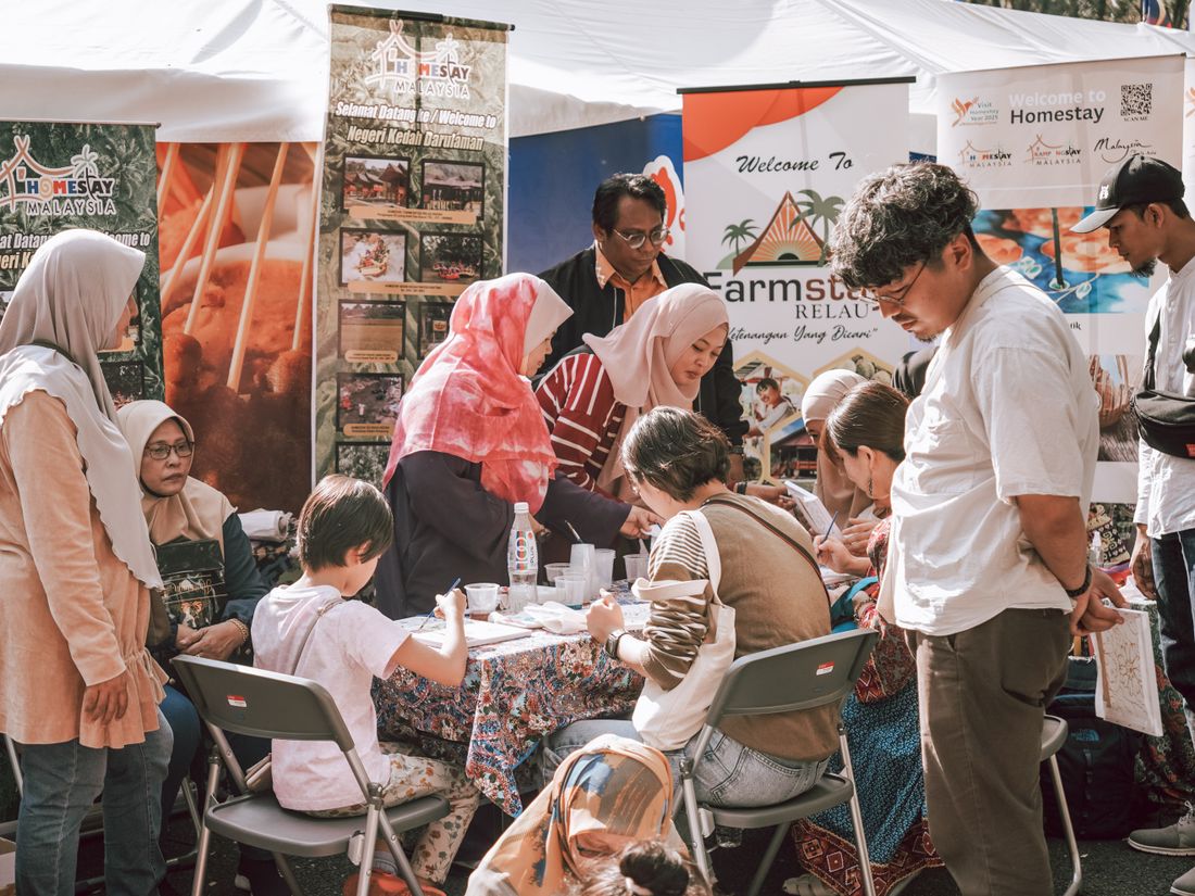 Attendees gathered around branded activation booths, engaging with staff and displays at an outdoor community event.
