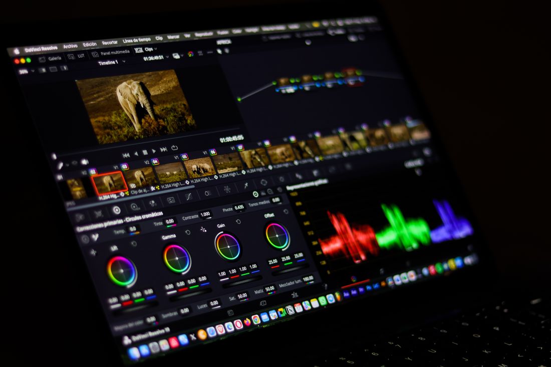 A color grading interface on a monitor showing color wheels and a video timeline