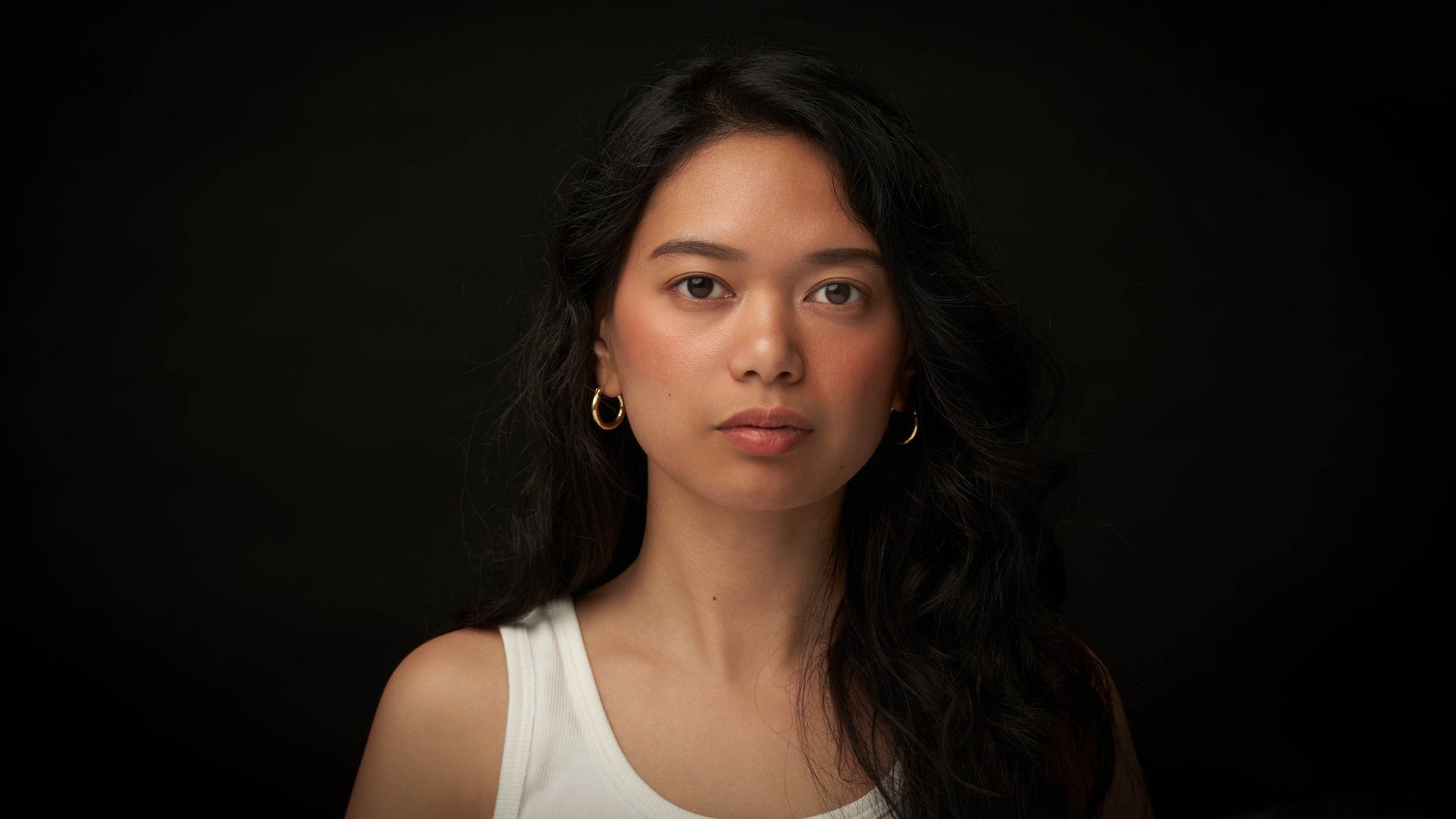 Professional headshot woman against plain black background