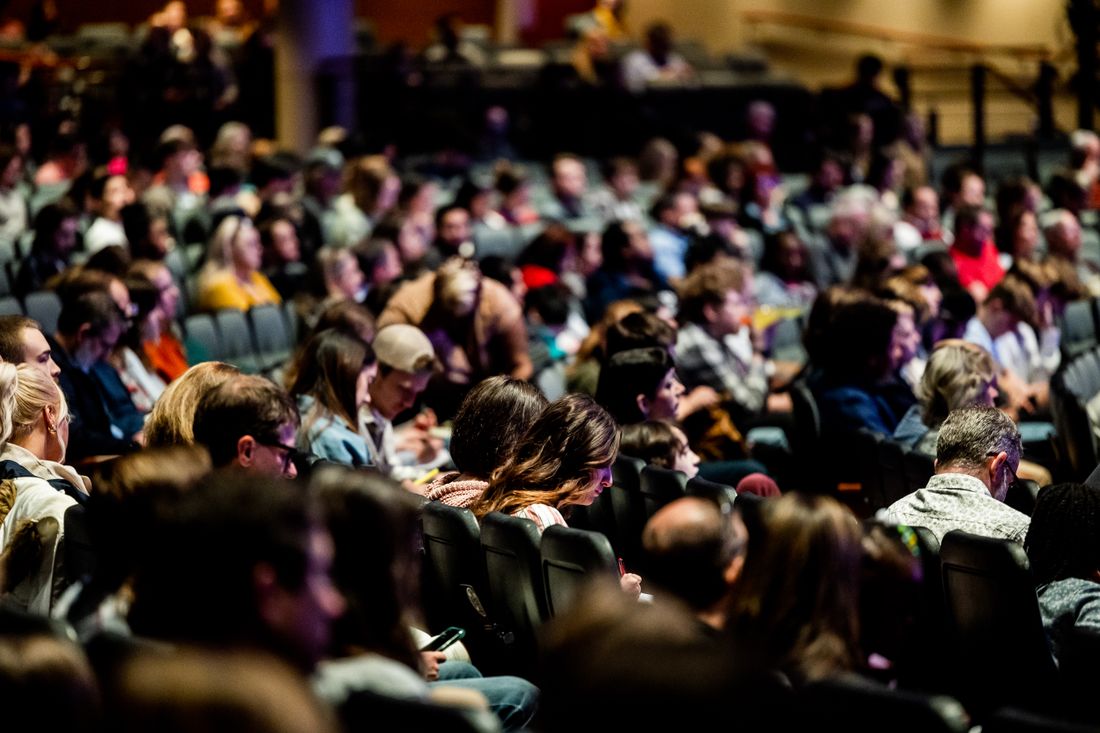 Diverse audience seated in rows at an indoor company meeting