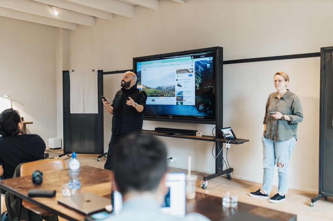Team presentation in an office with a screen showing work-related material to a seated group