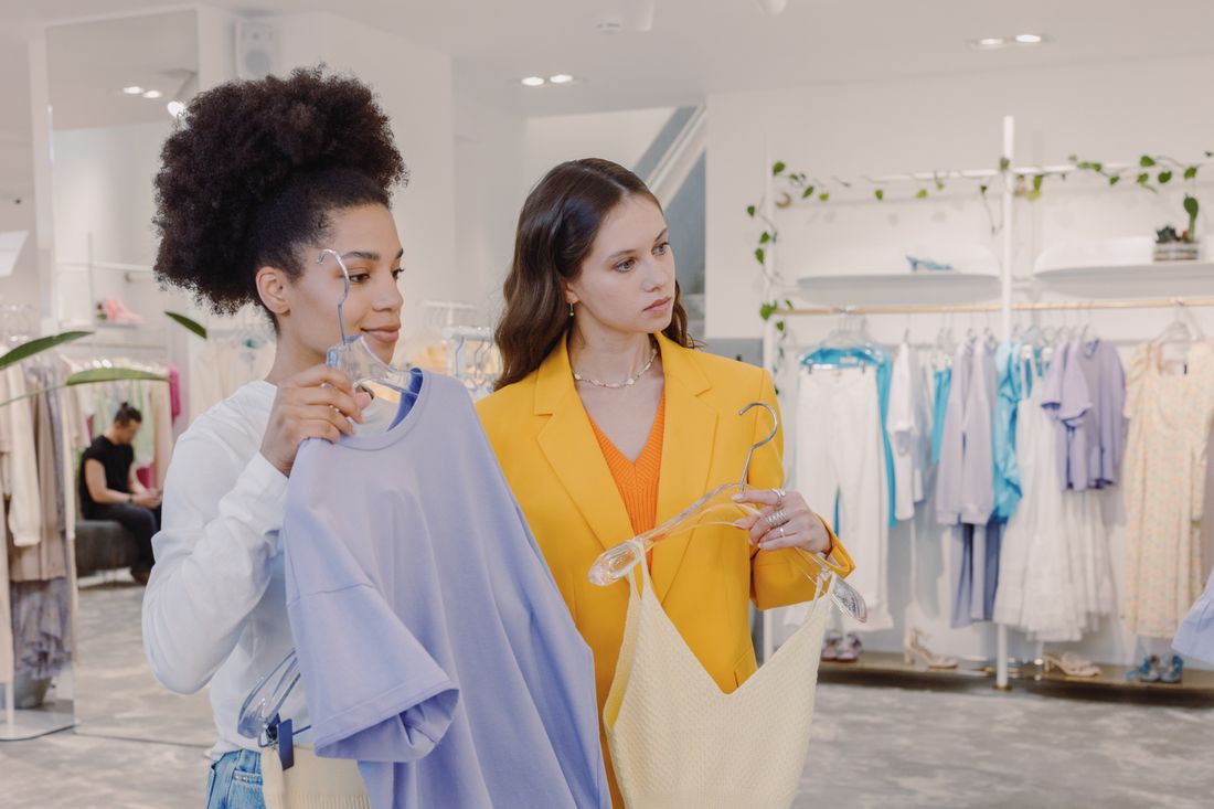 Two women examining a garment together during a one-on-one styling moment in a boutique.