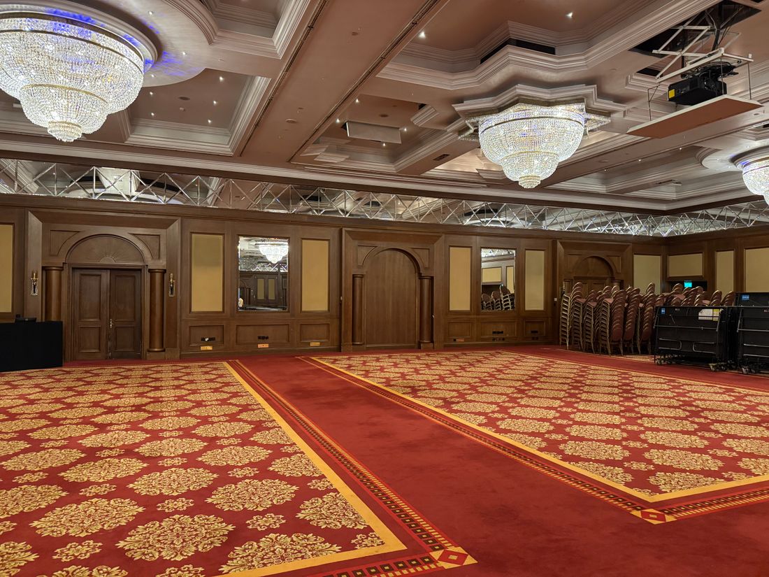Empty banquet hall with chandeliers and red carpet before an event setup