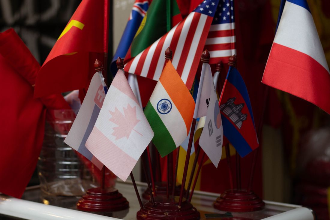 A cluster of small desk flags from different countries, representing a multilingual audience.