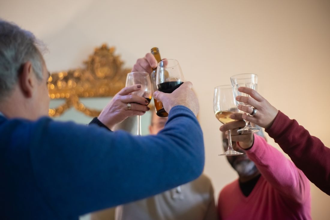 A group of people raising glasses in a toast during an indoor celebration.