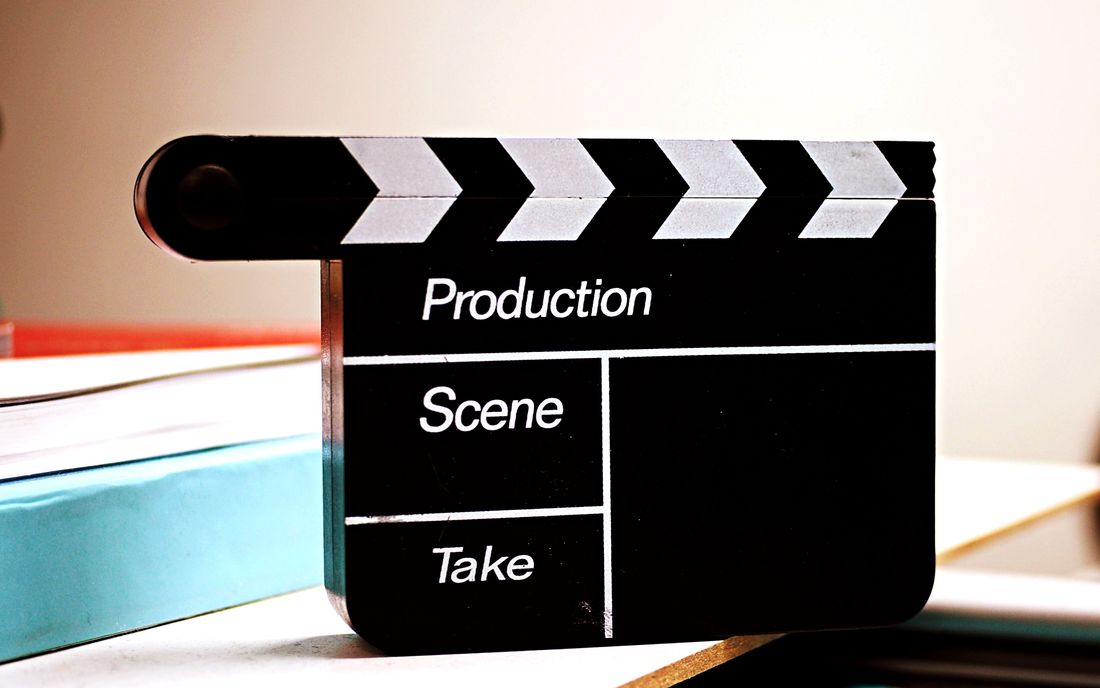 A close-up, black-and-white photo of a film clapperboard used to mark a production take.