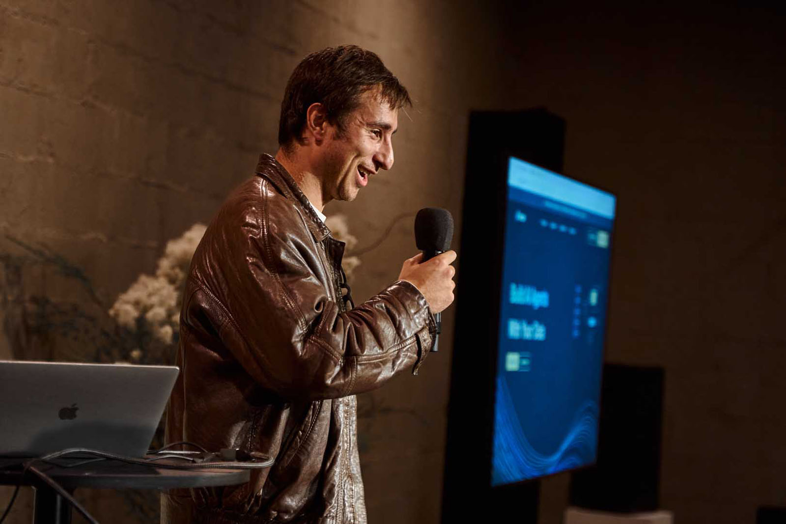 NYC tech event speaker with microphone dramatic stage photography